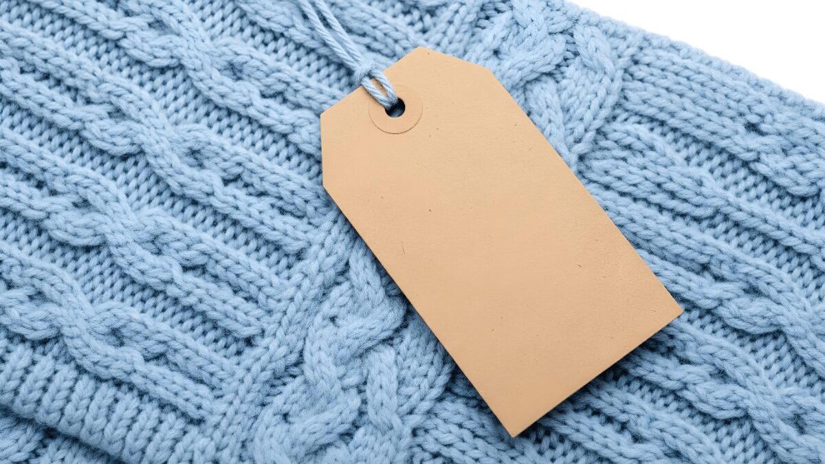 品質表示タグが付いたケーブル編みのニット