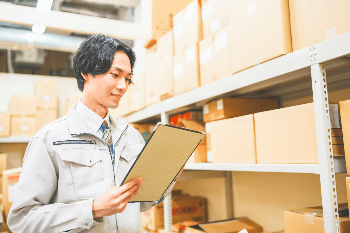 倉庫で革製品の検品内容を確認するスタッフ